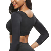 Woman wearing a black long-sleeve athletic top on a white background